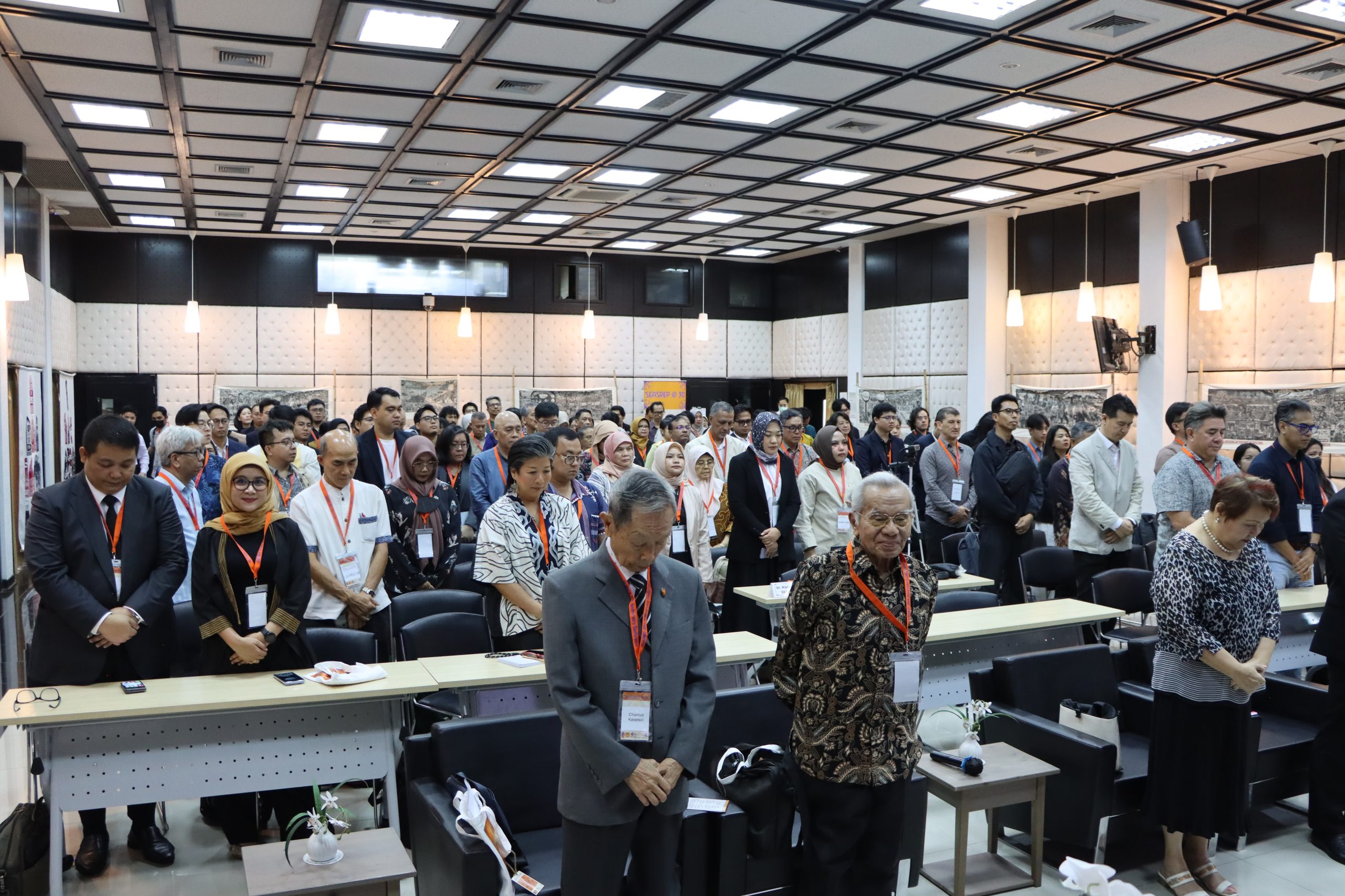 The conference participants observing a moment of silence for the recent passing of Her Majesty Queen Sirikit, the Queen Mothe, of Thailand.